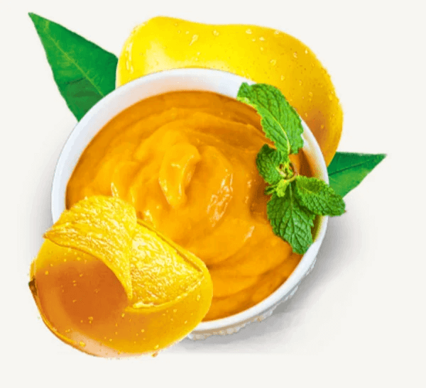 Bowl of thick golden Alphonso mango pulp with fresh mango slices